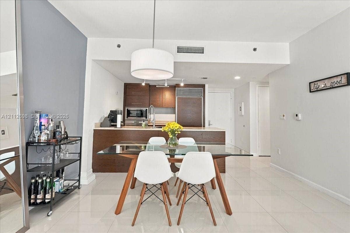 475 Brickell Avenue, #4511, Miami, FL 33131 Kitchen featuring dark wood-finish cabinetry, solid-surface countertops, built-in stainless steel appliances, and tile flooring