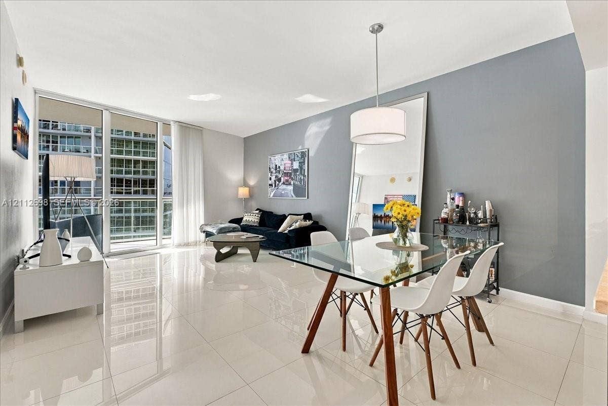 475 Brickell Avenue, #4511, Miami, FL 33131 Open-concept interior featuring polished porcelain tile flooring, expansive floor-to-ceiling windows, and a dedicated drum pendant light fixture