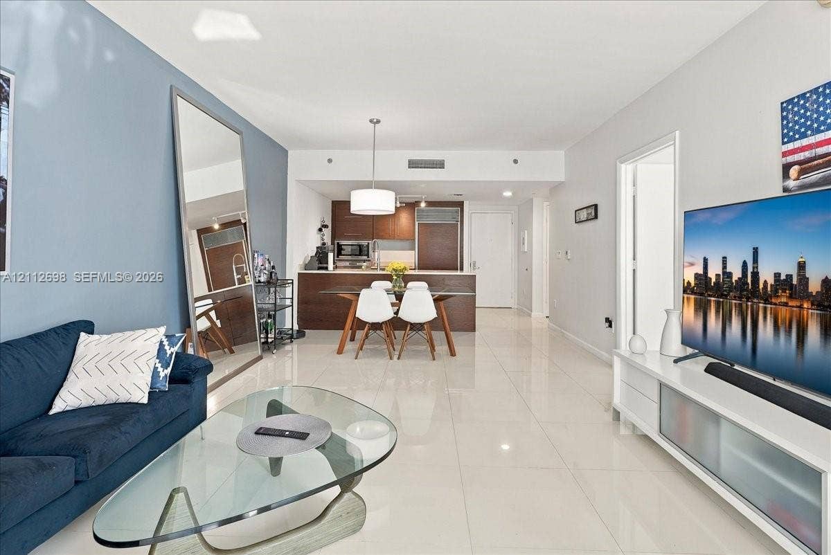 475 Brickell Avenue, #4511, Miami, FL 33131 Open-concept interior featuring light-toned tile flooring, recessed lighting, and kitchen cabinetry with a dark wood-finish