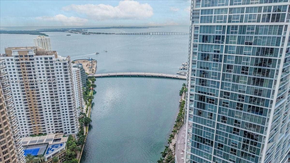 475 Brickell Avenue, #4511, Miami, FL 33131 High-rise residential exterior with glass window grid, water expanse, bridge, and coastal horizon