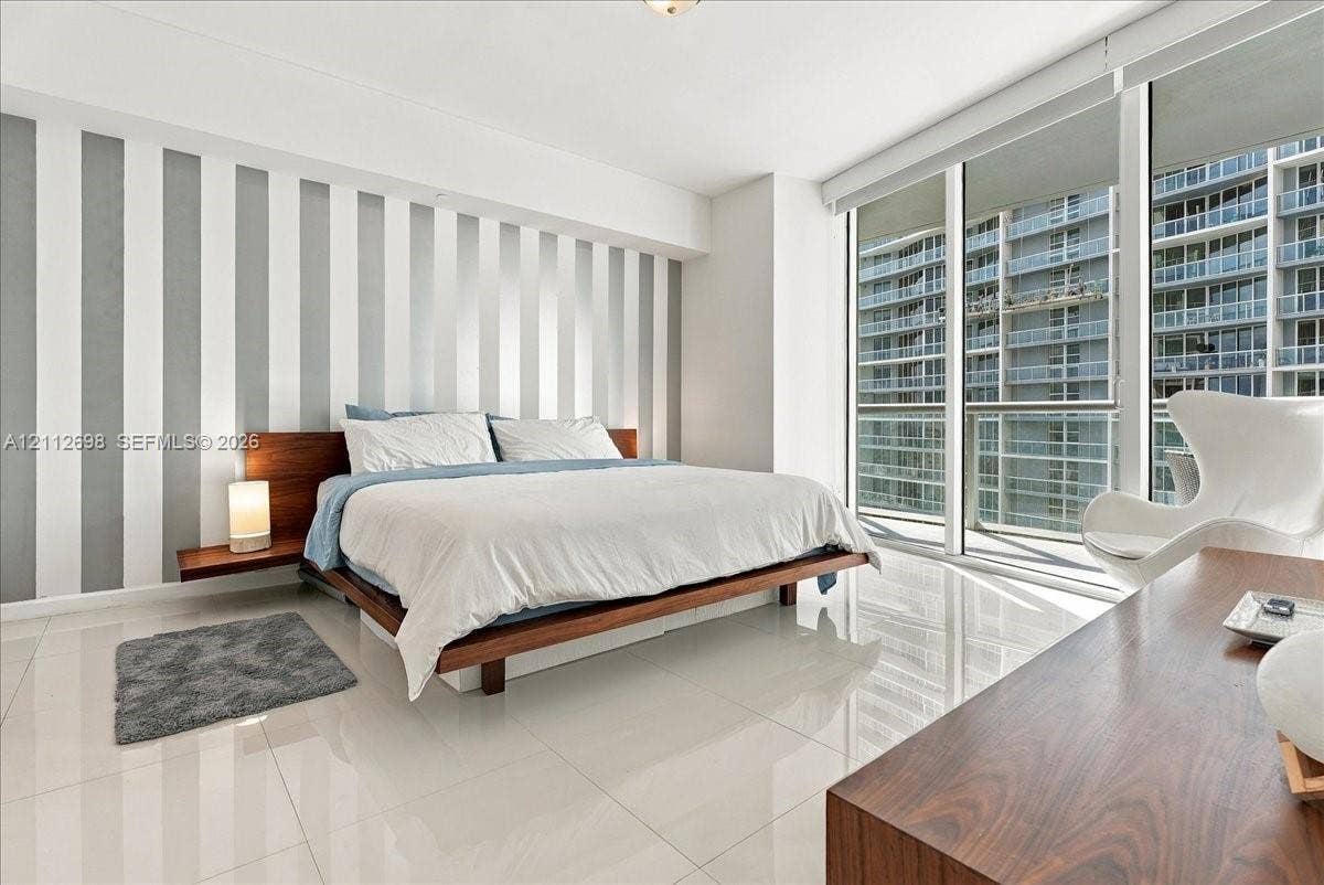 475 Brickell Avenue, #4511, Miami, FL 33131 Floor-to-ceiling windows, polished tile flooring, and integrated wall-mounted bedside shelving