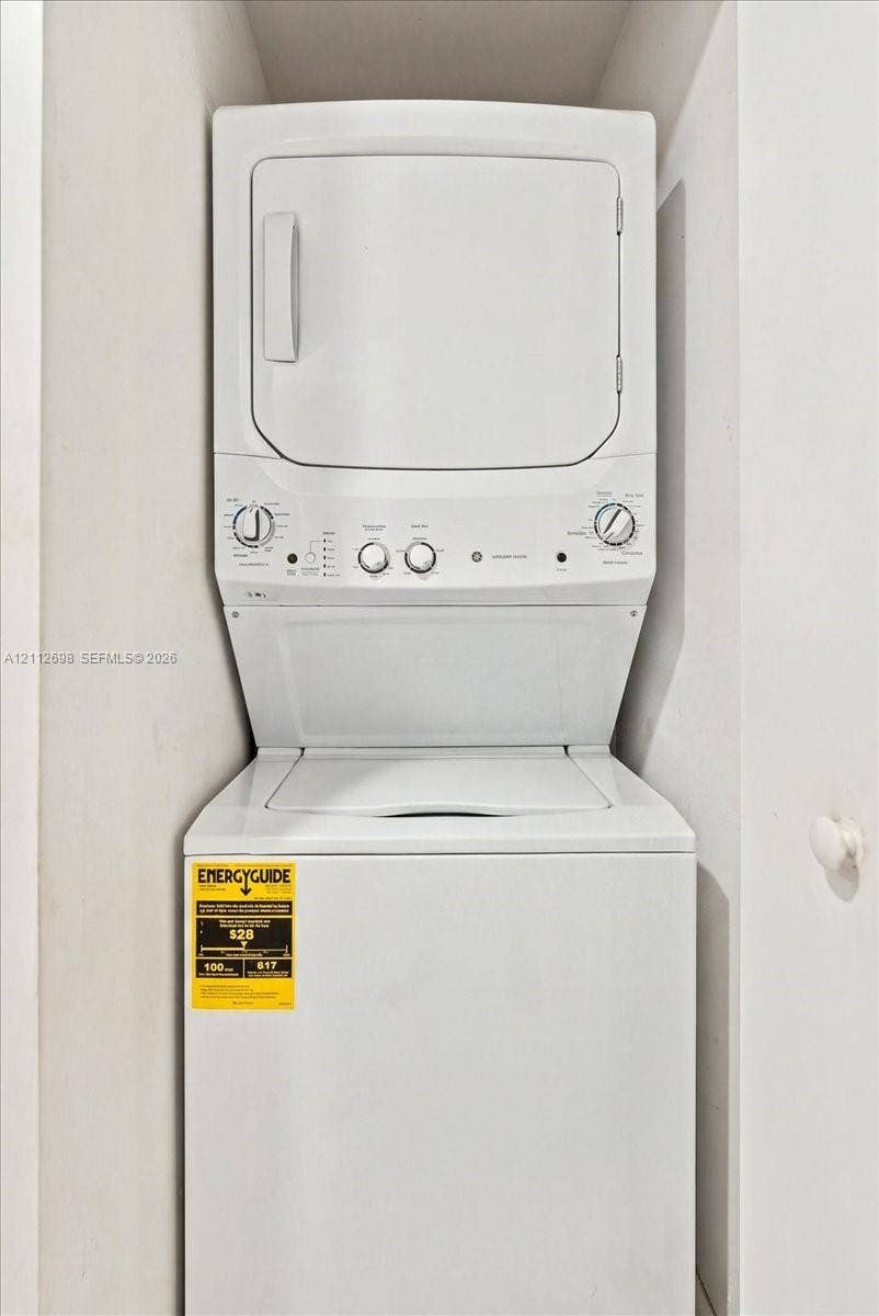 475 Brickell Avenue, #4511, Miami, FL 33131 Stackable white laundry unit featuring a top-loading washer and front-loading dryer enclosed within a recessed alcove