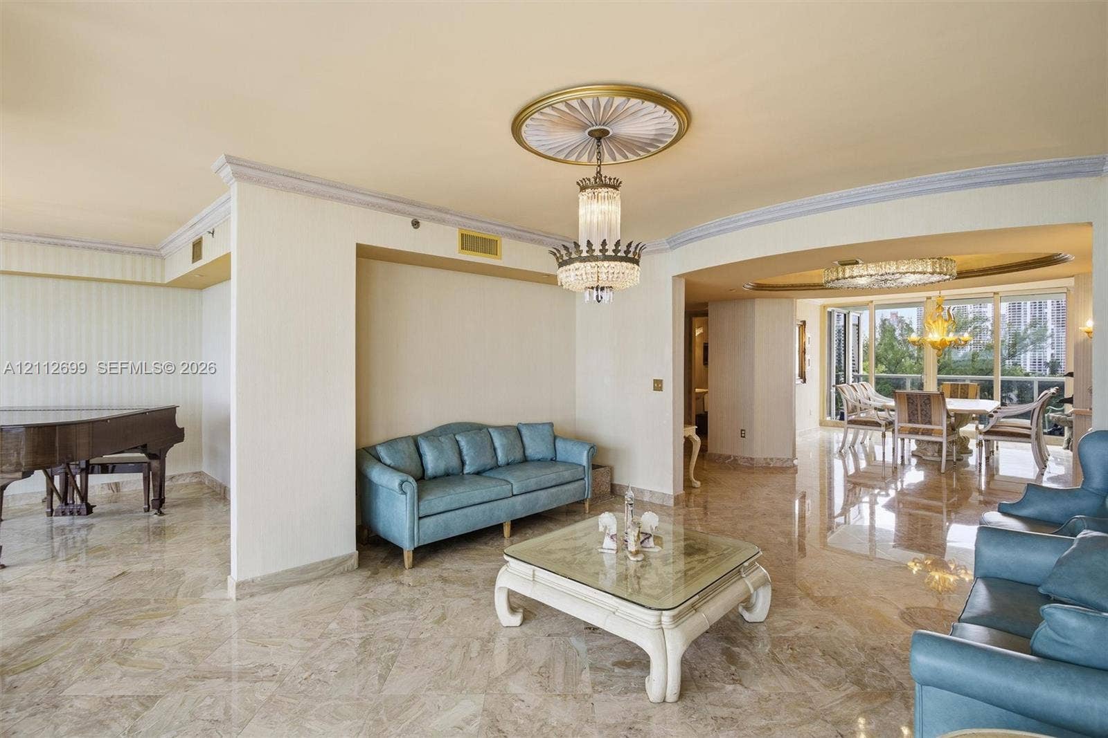 19111 Collins Avenue, #505, Sunny Isles Beach, FL 33160 Polished stone flooring, ornate ceiling medallion with a crystal tiered chandelier, multi-pane floor-to-ceiling windows, and recessed ceiling lighting