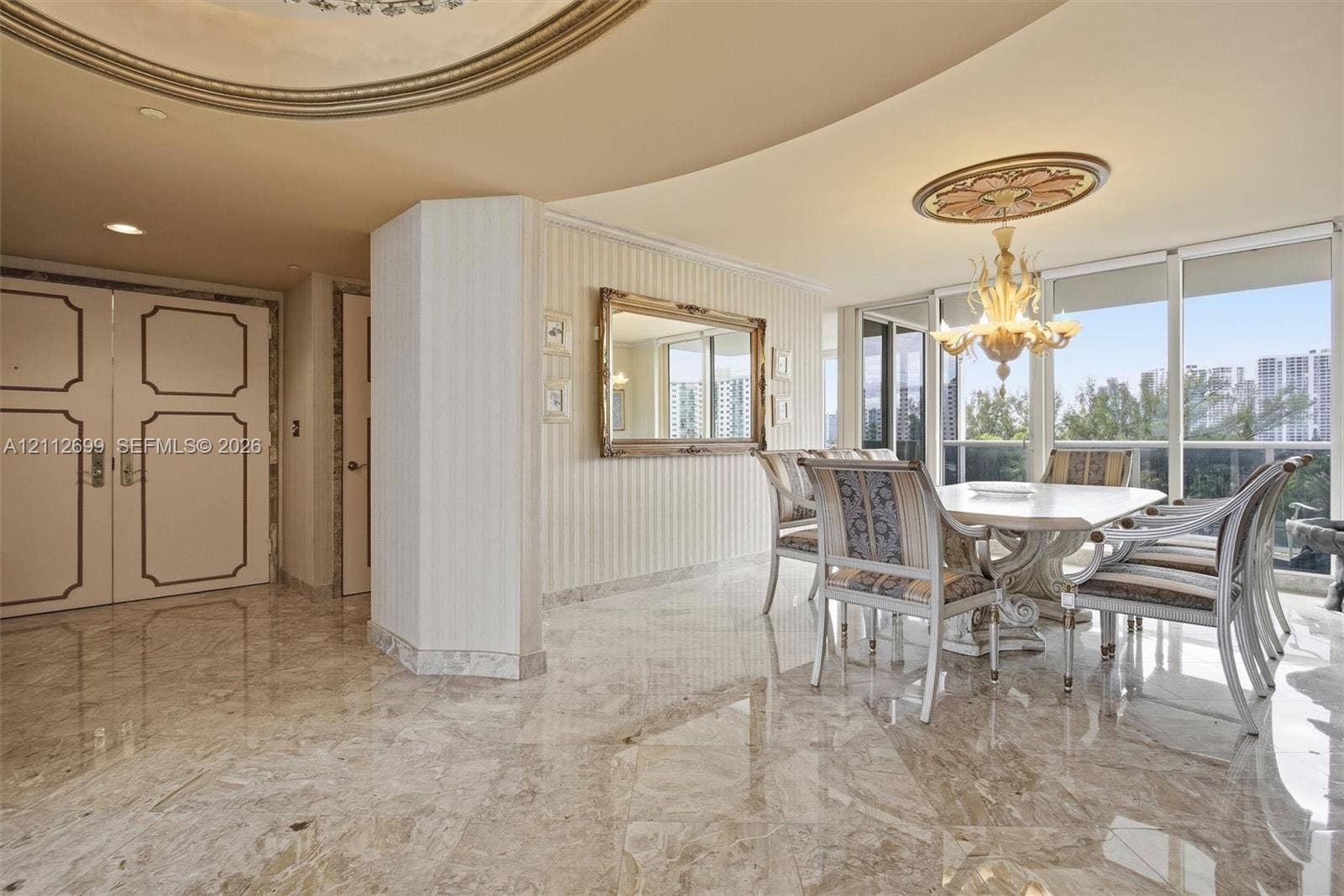 19111 Collins Avenue, #505, Sunny Isles Beach, FL 33160 Polished stone flooring, custom ceiling moulding, decorative ceiling medallion, ornate chandelier, and full-height windows