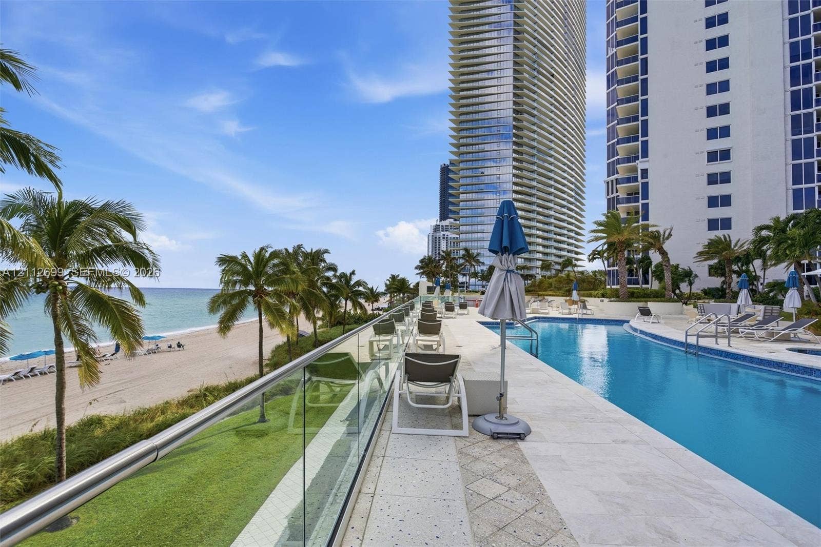 19111 Collins Avenue, #505, Sunny Isles Beach, FL 33160 Oceanfront swimming pool with tiled surround, glass panel railing, and direct sandy beach access