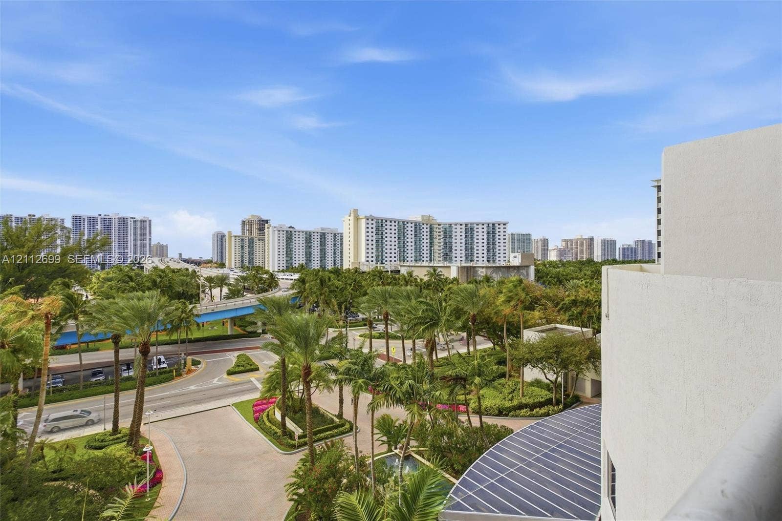19111 Collins Avenue, #505, Sunny Isles Beach, FL 33160 Elevated exterior balcony featuring a metal railing with expansive tropical landscaping and urban skyline scenery