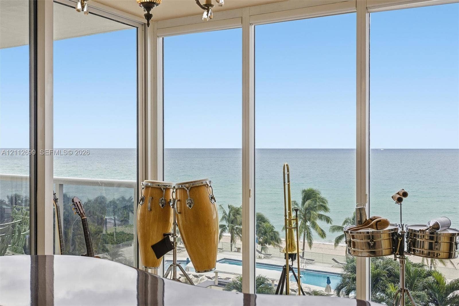 19111 Collins Avenue, #505, Sunny Isles Beach, FL 33160 Floor-to-ceiling windows featuring panoramic oceanfront exposure, exterior balcony with railing, and integrated overhead lighting fixture