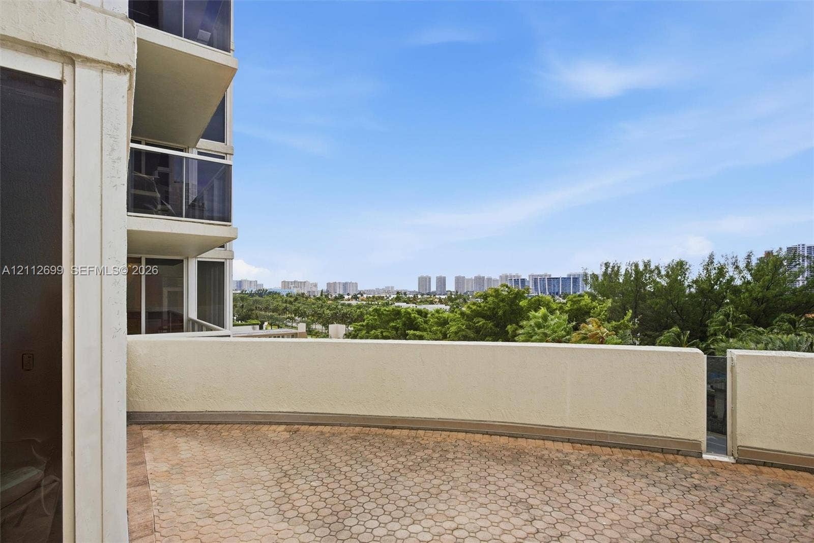 19111 Collins Avenue, #505, Sunny Isles Beach, FL 33160 2nd expansive private terrace featuring patterned paver flooring, perimeter walls with gorgeous sunset views.