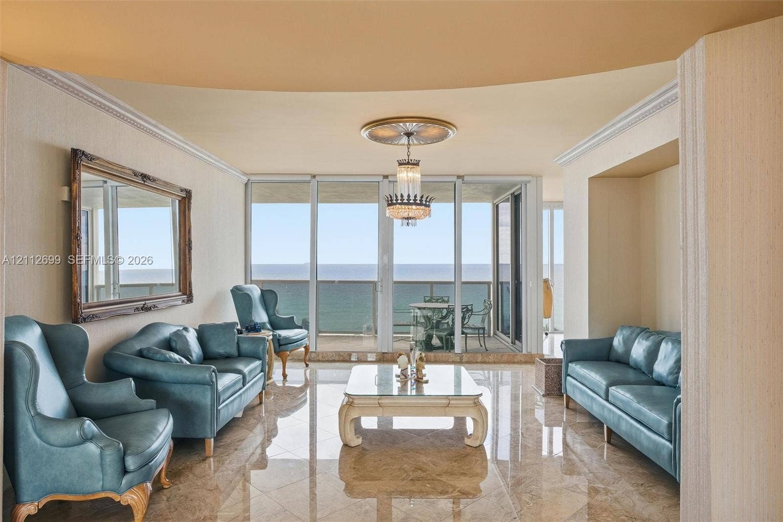 19111 Collins Avenue, #505, Sunny Isles Beach, FL 33160 Polished stone flooring, expansive floor-to-ceiling glass panel doors, crown molding, and a crystal chandelier