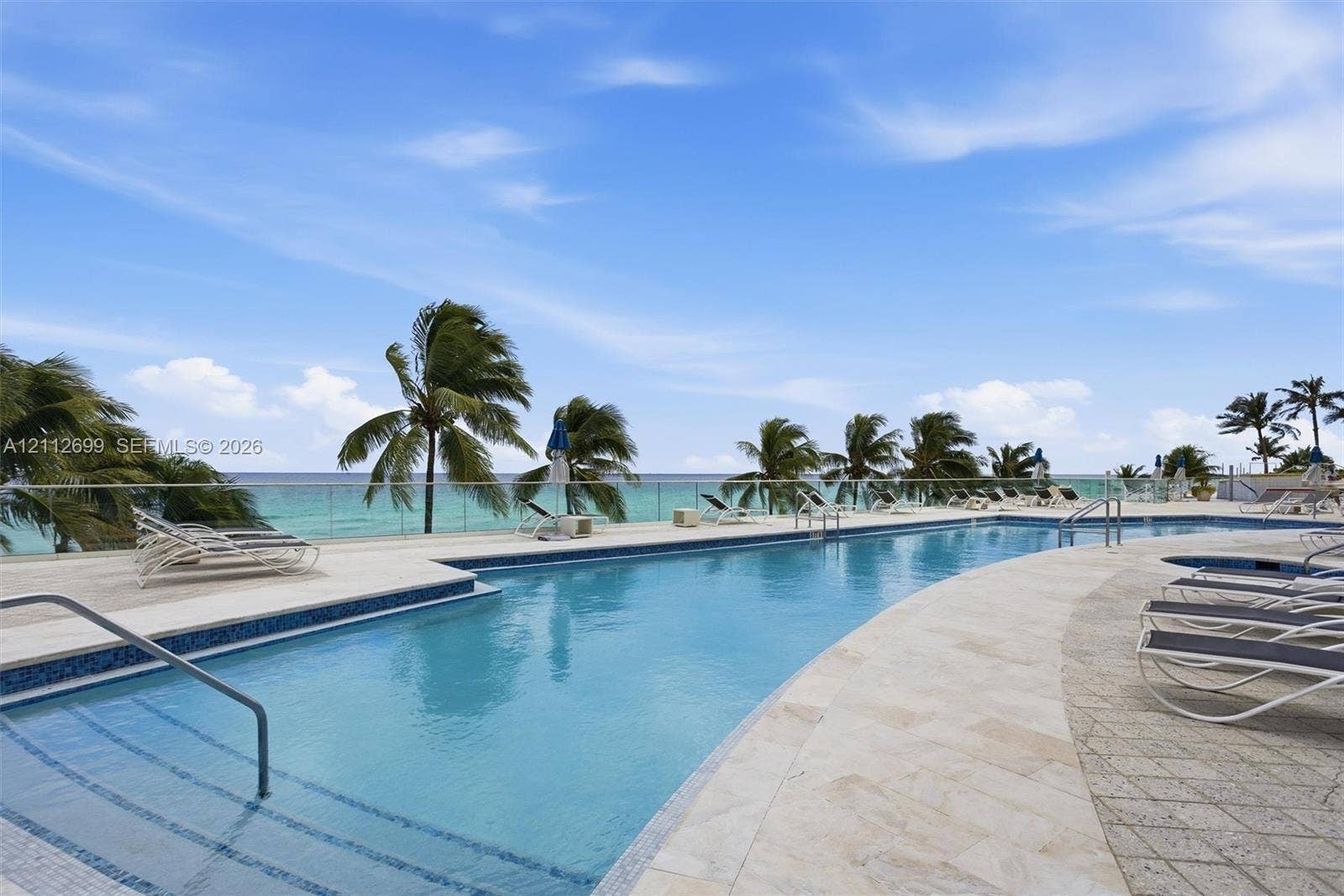 19111 Collins Avenue, #505, Sunny Isles Beach, FL 33160 Swimming pool with tiered entry steps, stone paver decking, and a glass panel perimeter railing