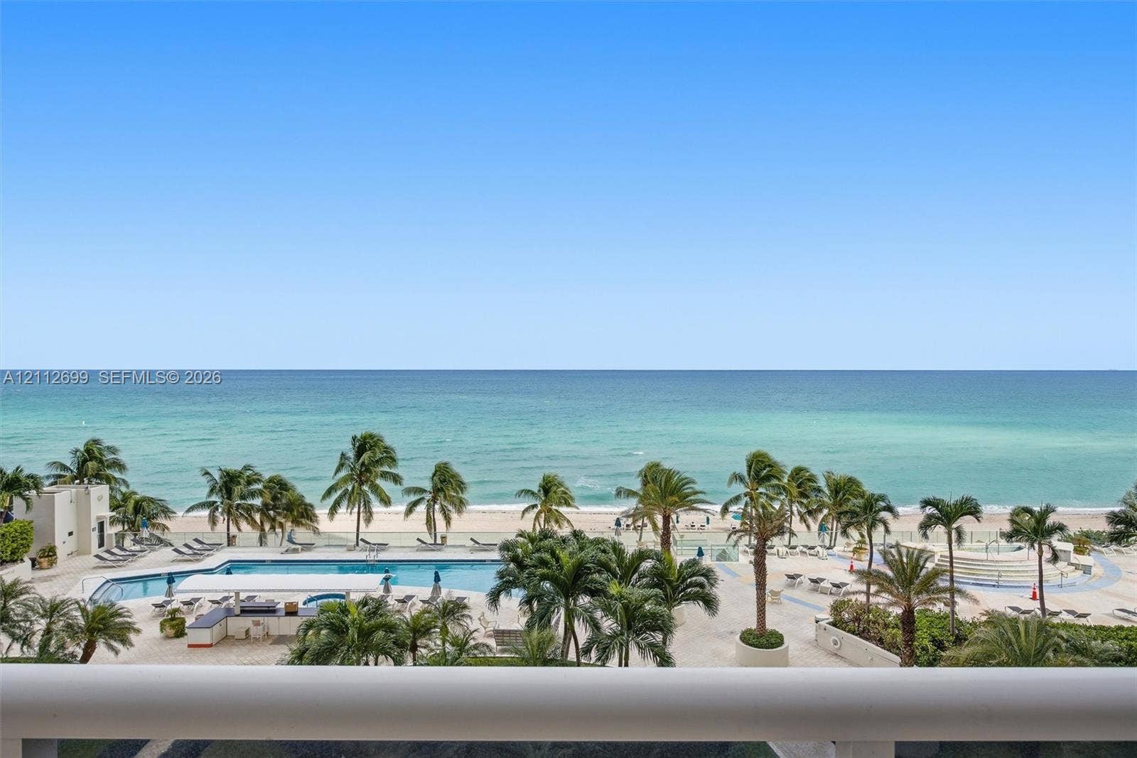 19111 Collins Avenue, #505, Sunny Isles Beach, FL 33160 Direct waterfront access with expansive ocean horizon, resort-style swimming pool, integrated poolside bar, and mature palm landscaping