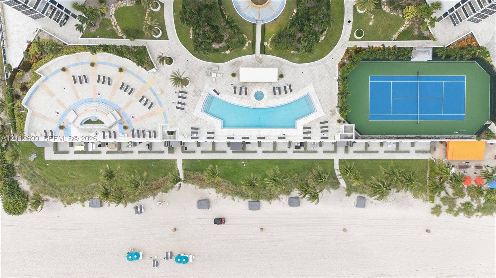 19111 Collins Avenue, #505, Sunny Isles Beach, FL 33160 Oceanfront grounds featuring a swimming pool, hard-court tennis court, landscaped gardens, and paved recreation terrace