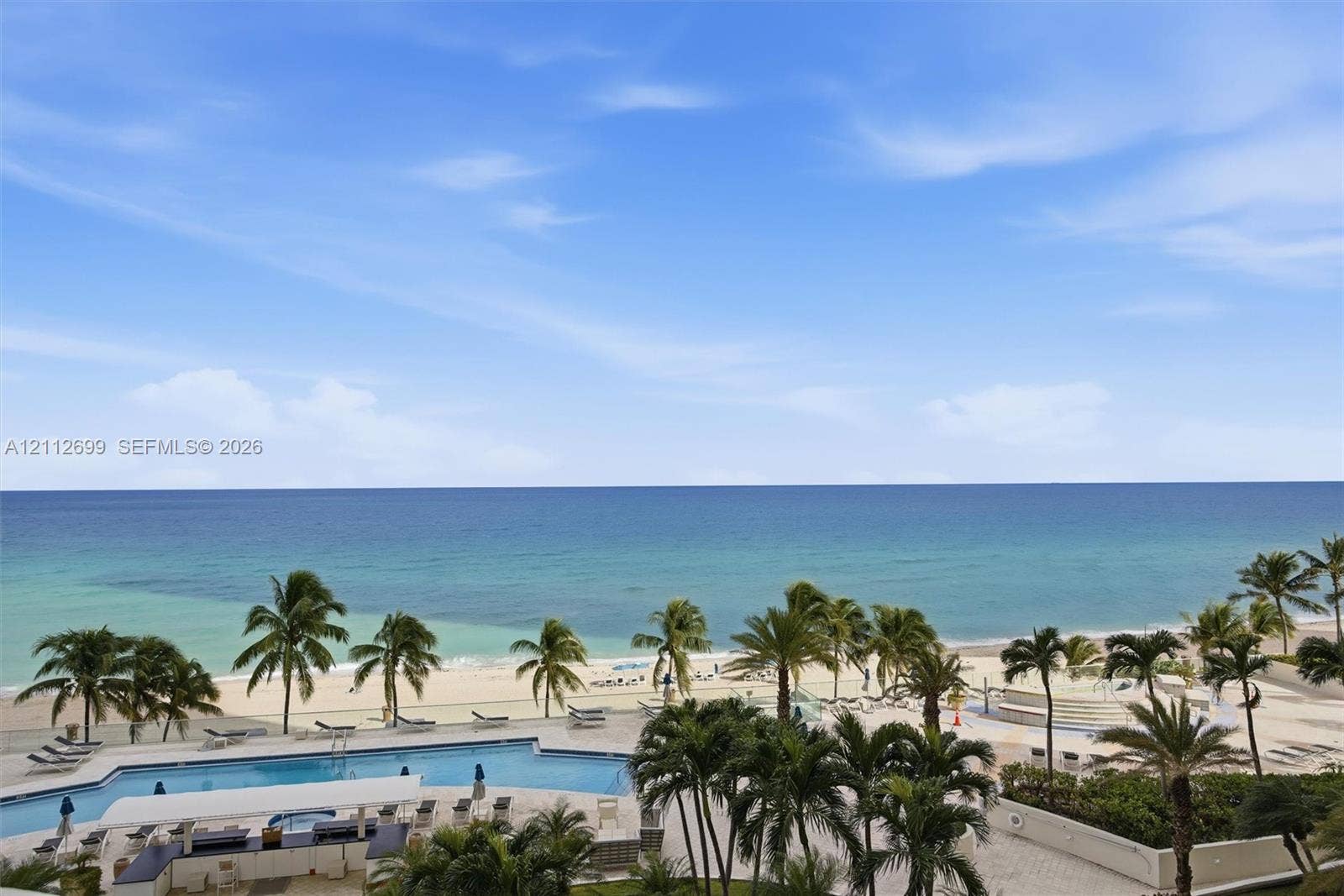 19111 Collins Avenue, #505, Sunny Isles Beach, FL 33160 Oceanfront property featuring a swimming pool, paved pool deck, and landscaped palm trees