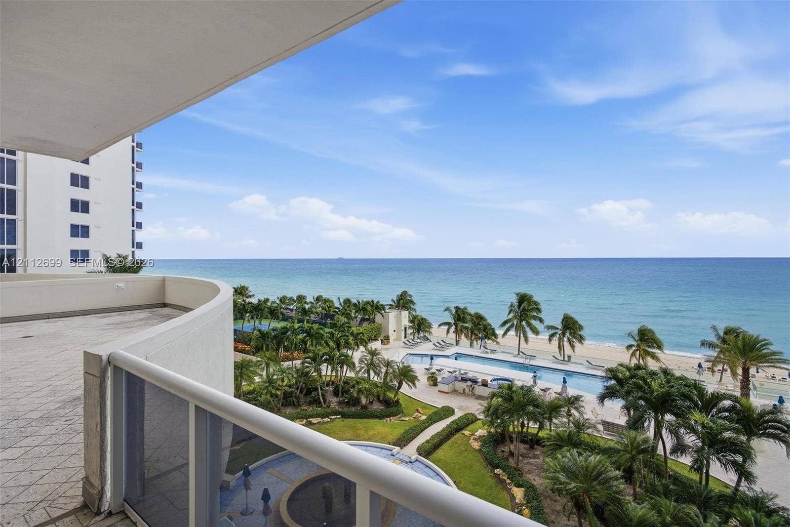 19111 Collins Avenue, #505, Sunny Isles Beach, FL 33160 Covered balcony featuring tile flooring and a glass-paneled railing connects to oversized large terrace.