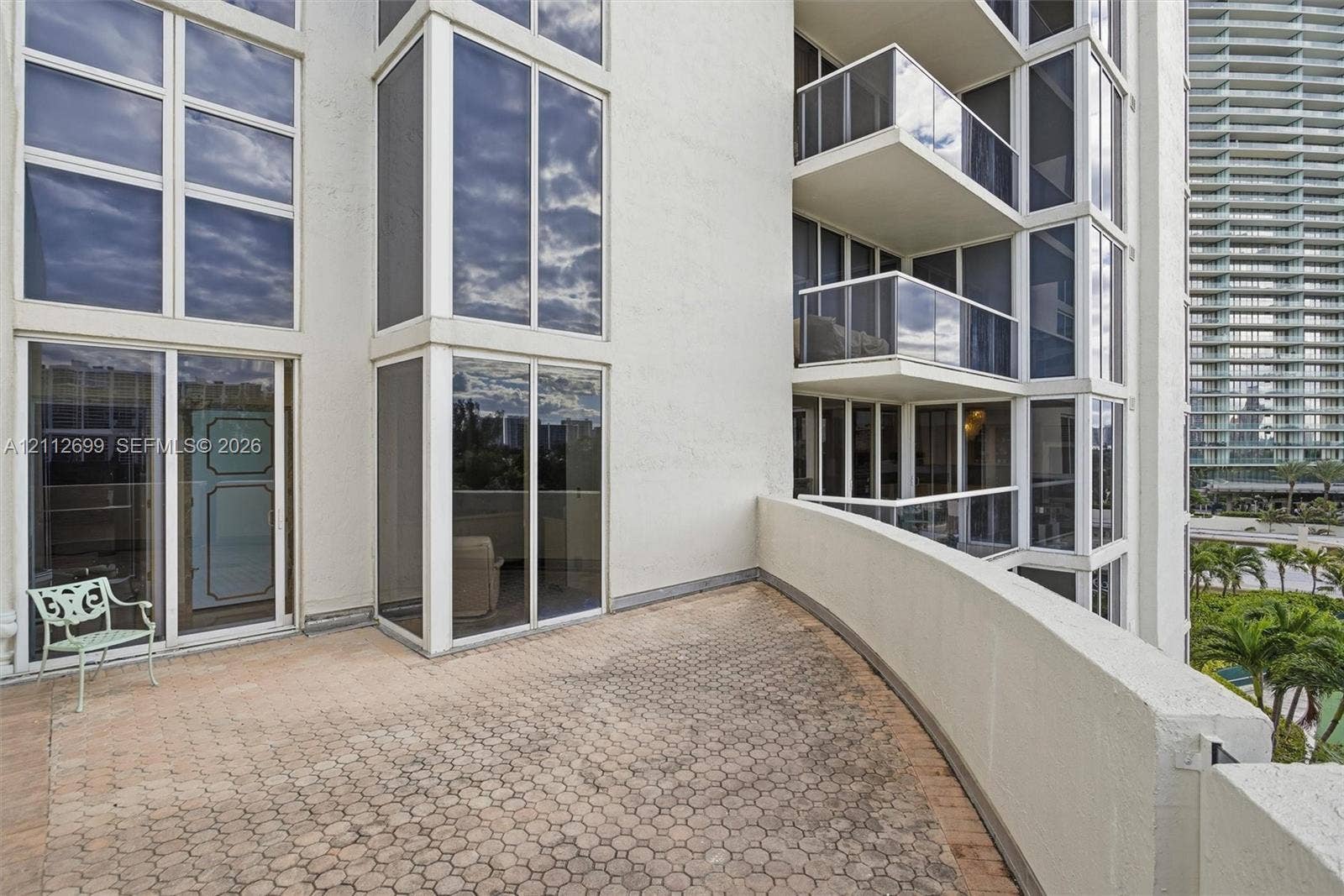 19111 Collins Avenue, #505, Sunny Isles Beach, FL 33160 Expansive private balcony featuring patterned paver flooring, floor-to-ceiling glass paneling, and glass-paneled railings