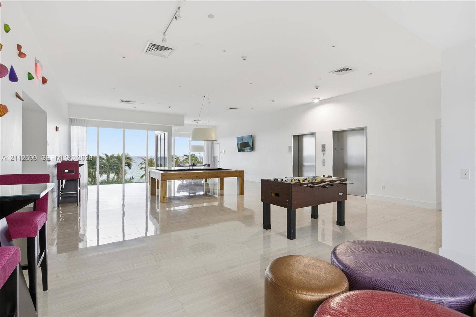 19111 Collins Avenue, #505, Sunny Isles Beach, FL 33160 Open-concept common area featuring high-gloss tile flooring, floor-to-ceiling glass wall, recessed track lighting, and dual elevator access