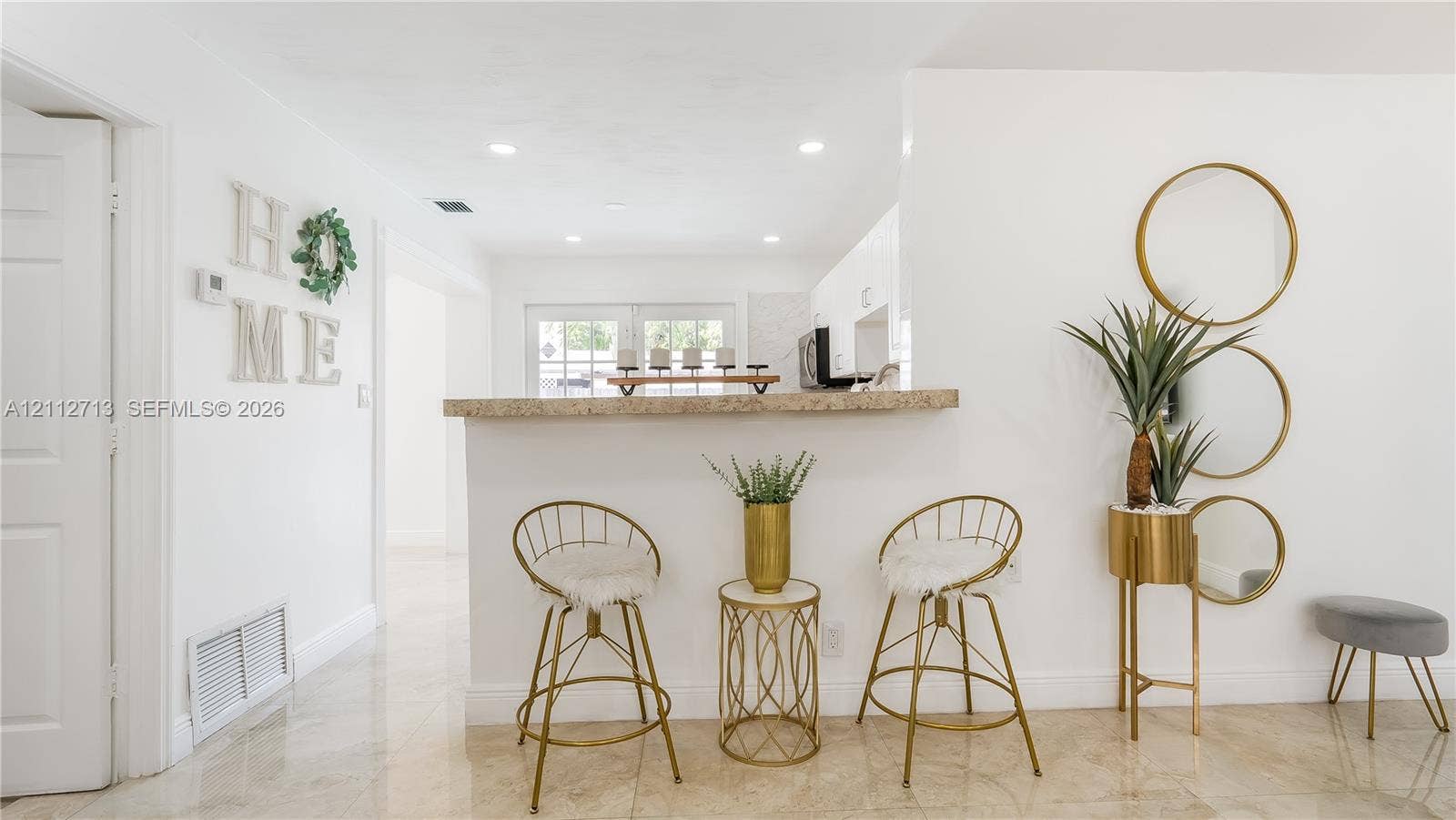 Pass-through service bar with a stone-finish countertop and recessed ceiling lighting throughout the interior