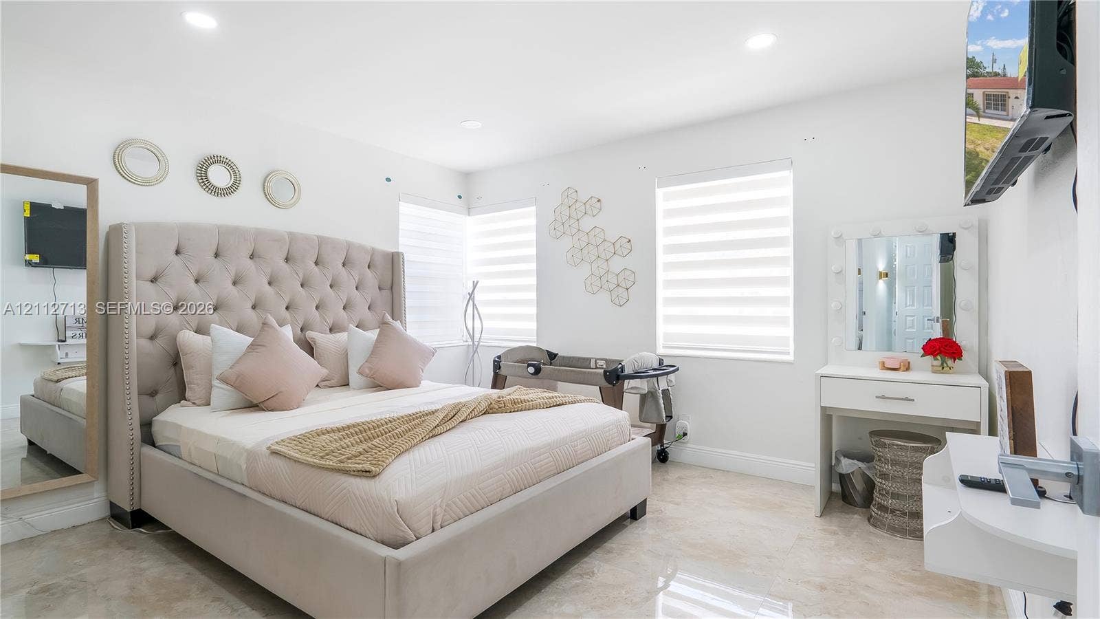 Interior space featuring neutral stone-finish flooring, recessed lighting, and dual-shade window treatments