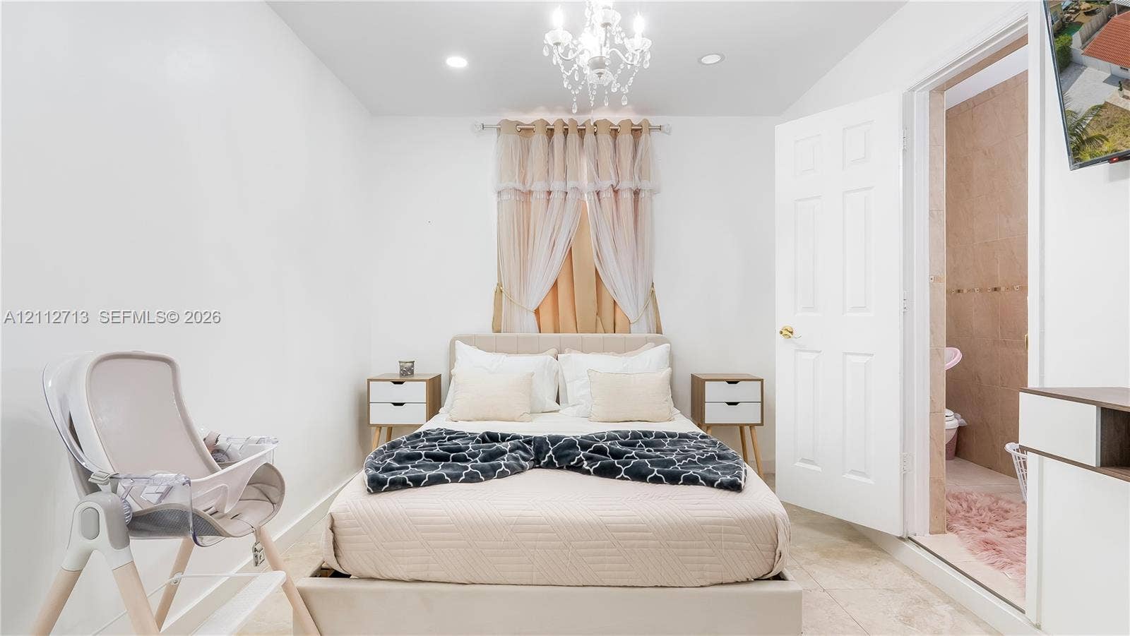 Interior space featuring neutral tile flooring, recessed lighting, and a multi-tiered crystal chandelier