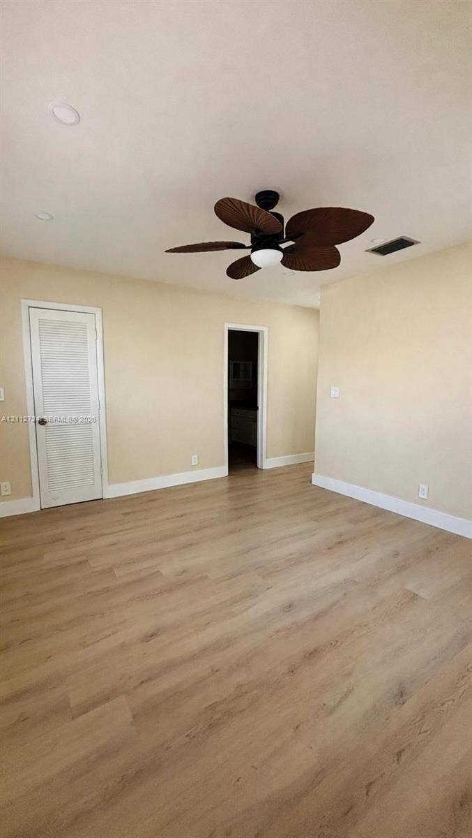 Room featuring wood-finish flooring, recessed lighting, and a multi-blade ceiling fan with an integrated light fixture
