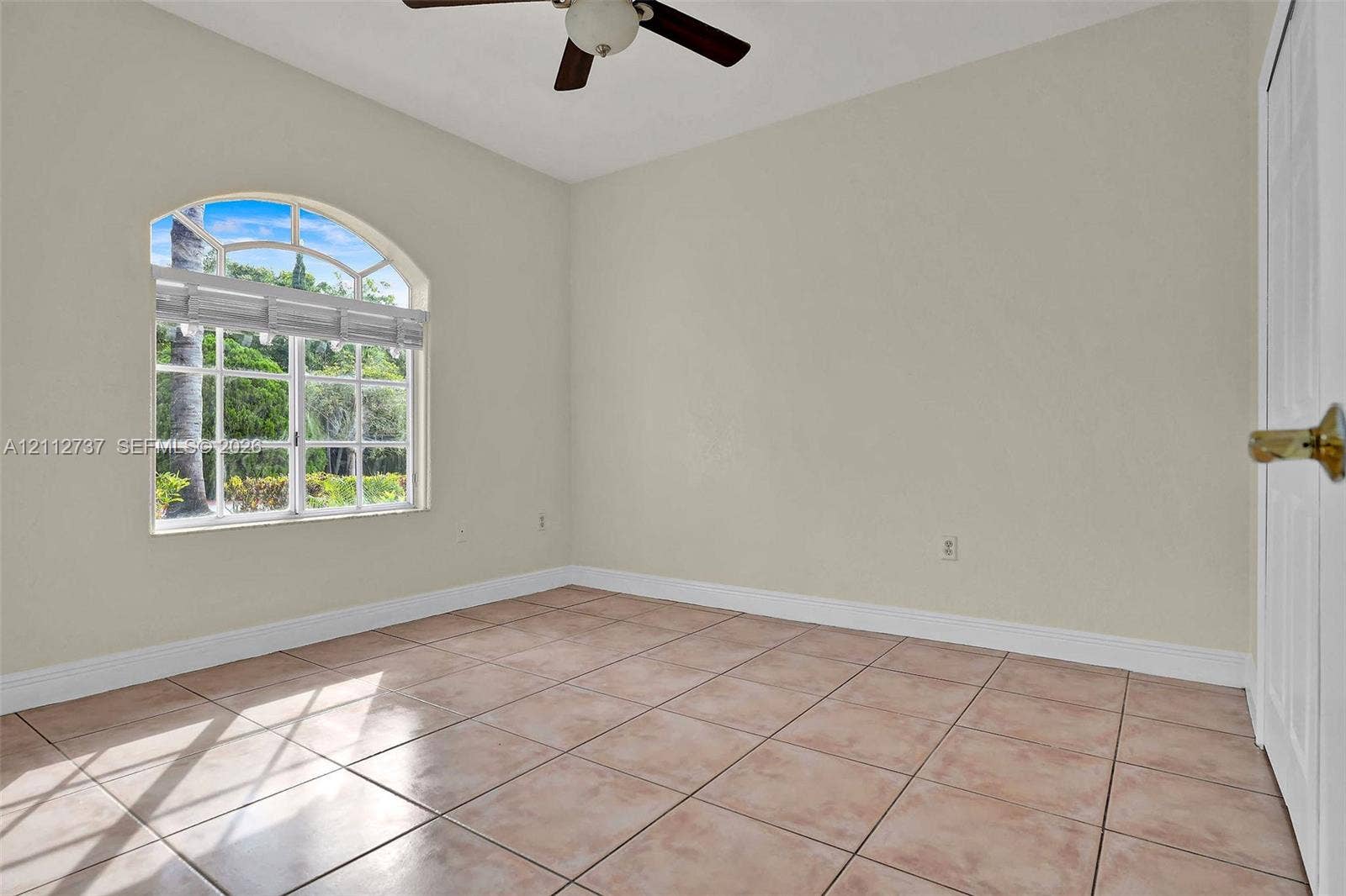 27902 SW 159th Court, Homestead, FL 33031 Arched window featuring grid detailing, ceramic tile flooring, and ceiling fan with integrated lighting