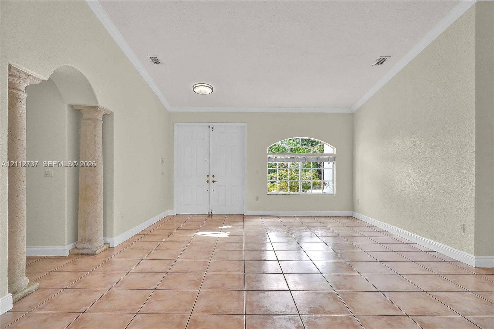 27902 SW 159th Court, Homestead, FL 33031 Vaulted ceilings, arched entry with dual stone-finish pillars, ceramic tile flooring, double front entry doors, and an arched window