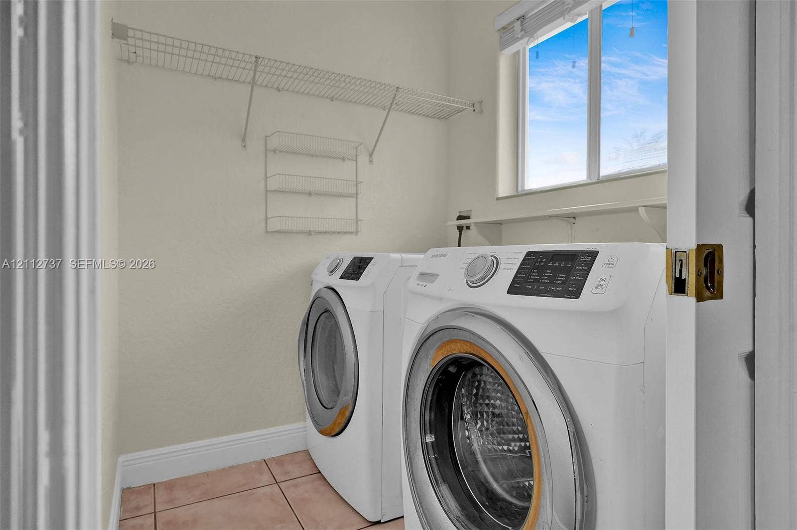 27902 SW 159th Court, Homestead, FL 33031 Laundry area featuring ceramic tile flooring, a window, and white wire wall-mounted shelving