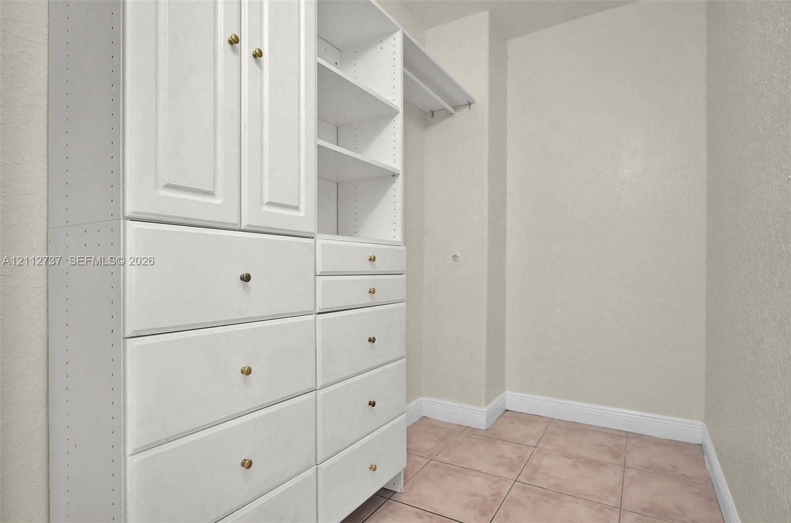 27902 SW 159th Court, Homestead, FL 33031 Built-in storage system featuring white cabinetry, tiered shelving, integrated drawers, and tile flooring