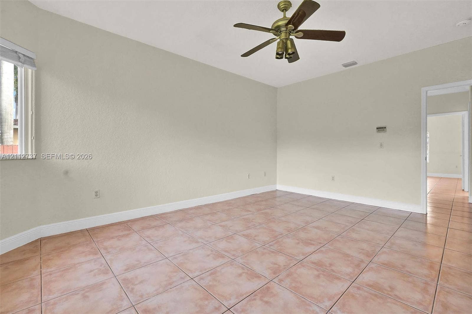 27902 SW 159th Court, Homestead, FL 33031 Neutral-toned interior featuring ceramic tile flooring, a multi-blade ceiling fan with integrated lighting, and a single-hung window