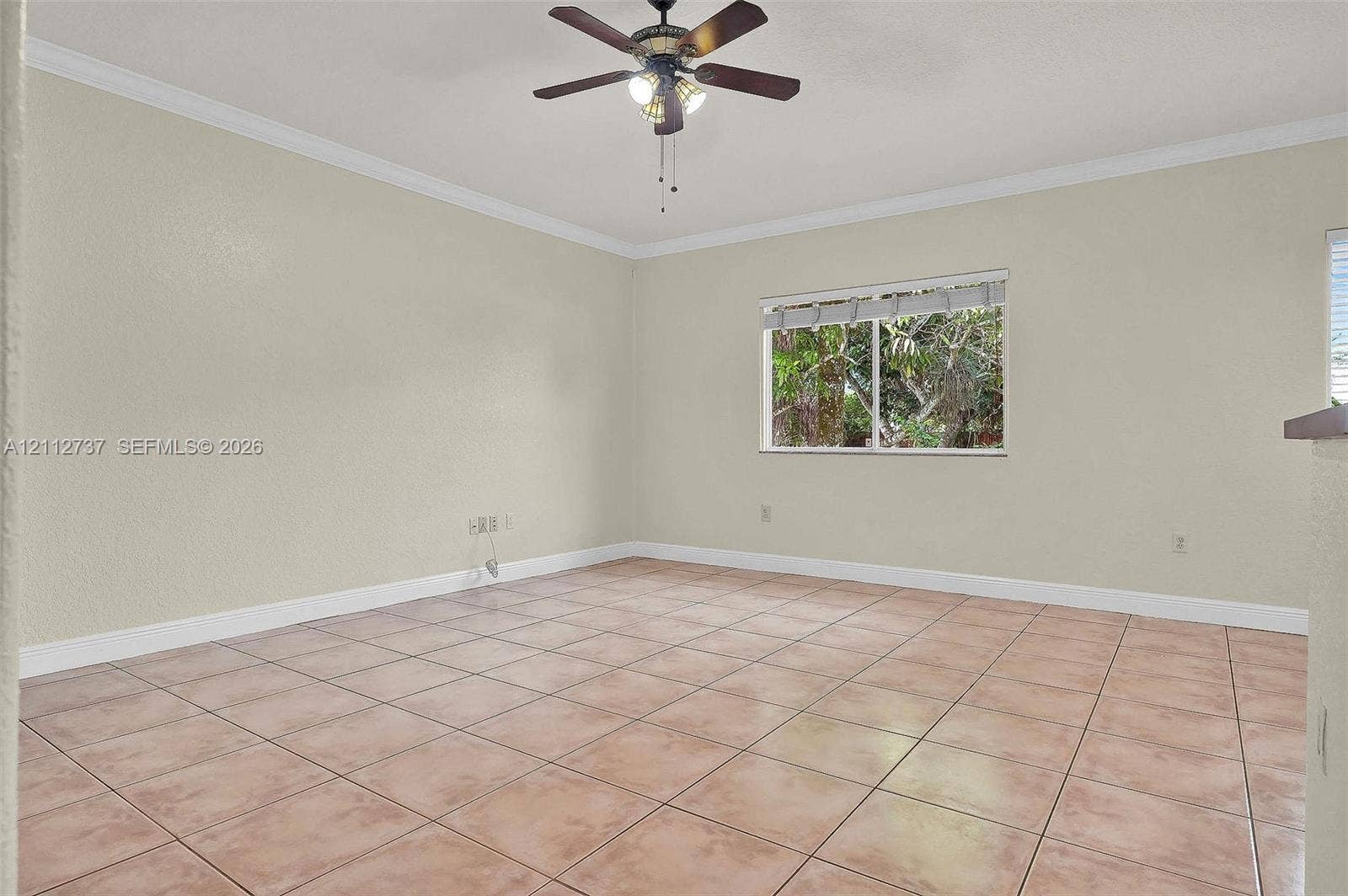 27902 SW 159th Court, Homestead, FL 33031 Neutral-toned interior featuring ceramic tile flooring, crown molding, and a multi-light ceiling fan