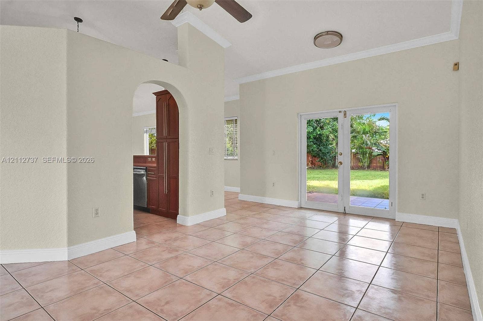 27902 SW 159th Court, Homestead, FL 33031 Interior space featuring large-format ceramic tile flooring, arched architectural detailing, and dual glass paneled doors providing exterior access