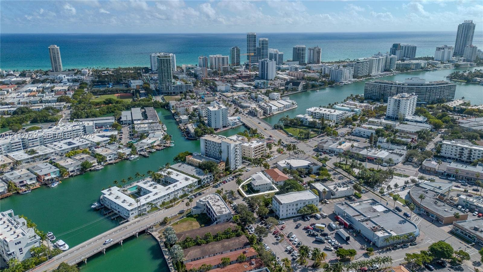 7124 Bay Drive, Miami Beach, FL 33141 Aerial perspective highlighting a multi-story building located along a coastal waterway in an urban setting