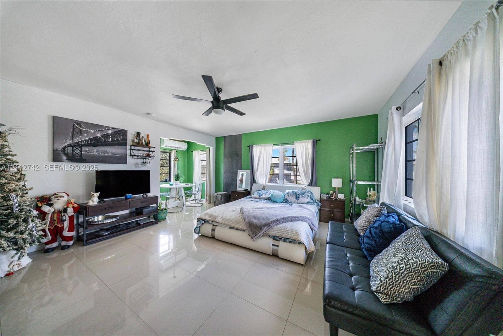 7124 Bay Drive, Miami Beach, FL 33141 Spacious room featuring polished tile flooring, ceiling fan, and large windows with integrated hardware
