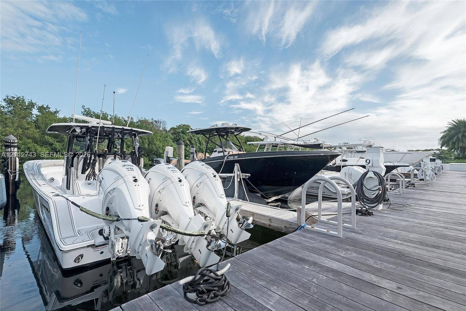 6157 Paradise Point Drive, Palmetto Bay, FL 33157 Deep-water boat slips featuring wooden decking, concrete pilings, and integrated ladders