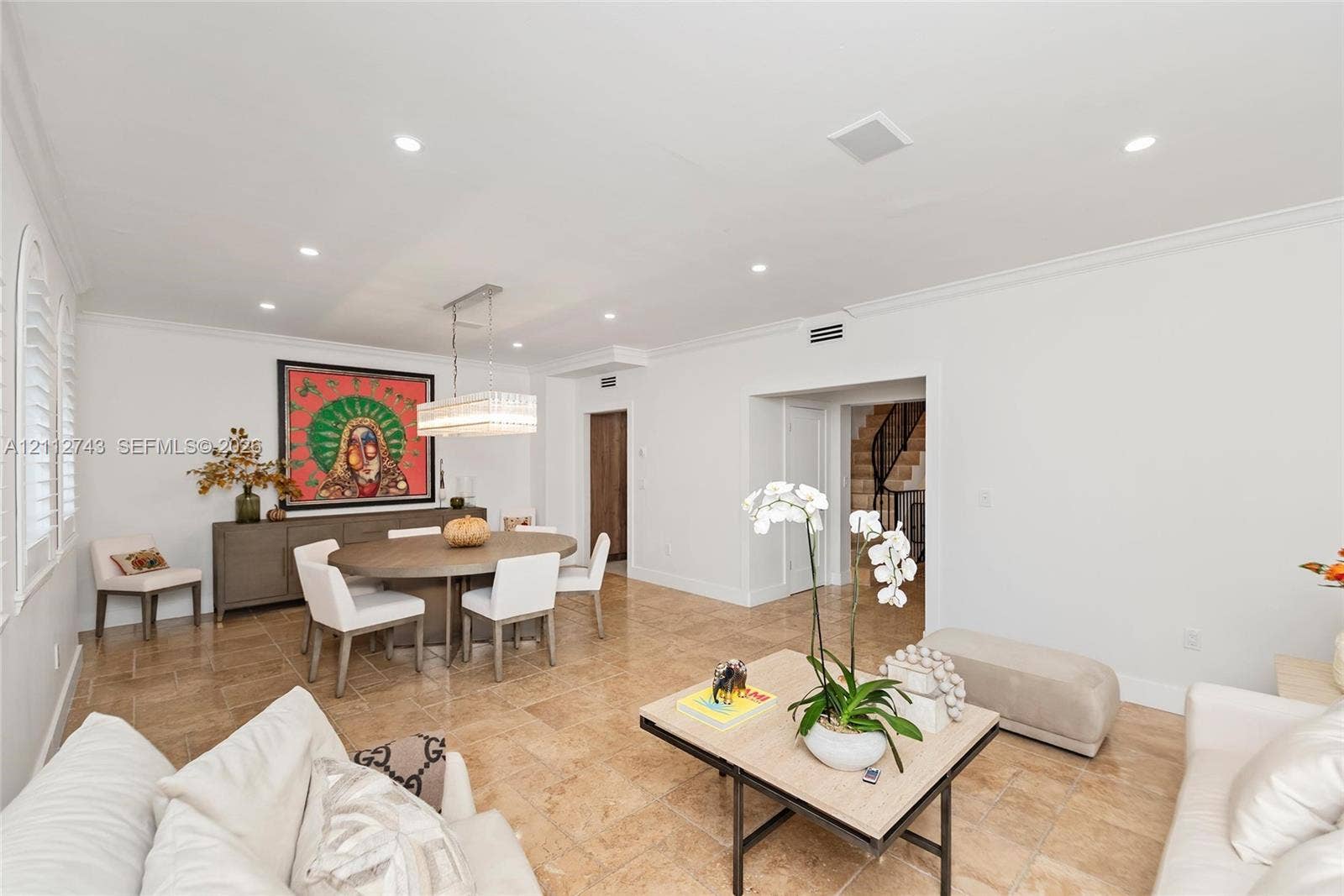 6157 Paradise Point Drive, Palmetto Bay, FL 33157 Open-concept area featuring stone tile flooring, crown molding, recessed lighting, and a rectangular multi-tiered crystal chandelier