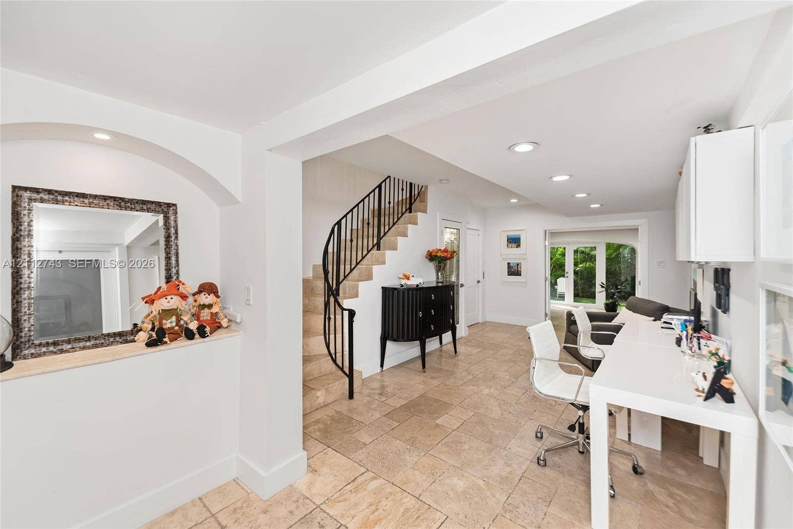 6157 Paradise Point Drive, Palmetto Bay, FL 33157 Interior space featuring stone-tile flooring, a curved staircase with metal railing, built-in wall niche with recessed lighting, and recessed ceiling lighting throughout