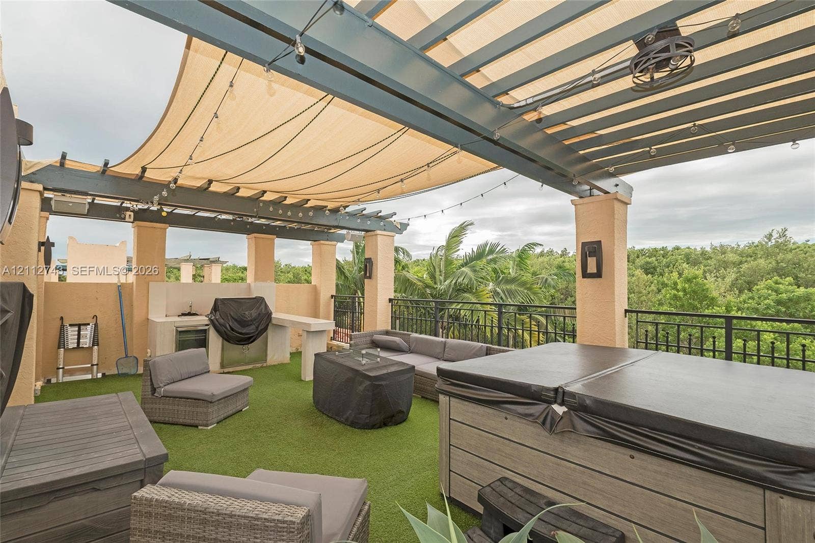 6157 Paradise Point Drive, Palmetto Bay, FL 33157 Rooftop terrace featuring a covered pergola with a retractable shade canopy, built-in outdoor kitchen, integrated lighting, and a composite-finish hot tub