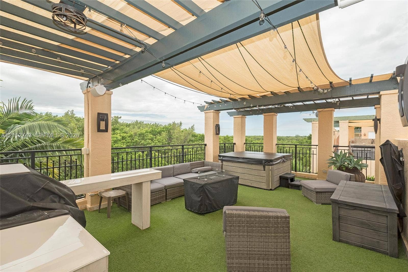 6157 Paradise Point Drive, Palmetto Bay, FL 33157 Rooftop terrace featuring a covered pergola, integrated overhead lighting, metal railings, and a built-in outdoor kitchen structure