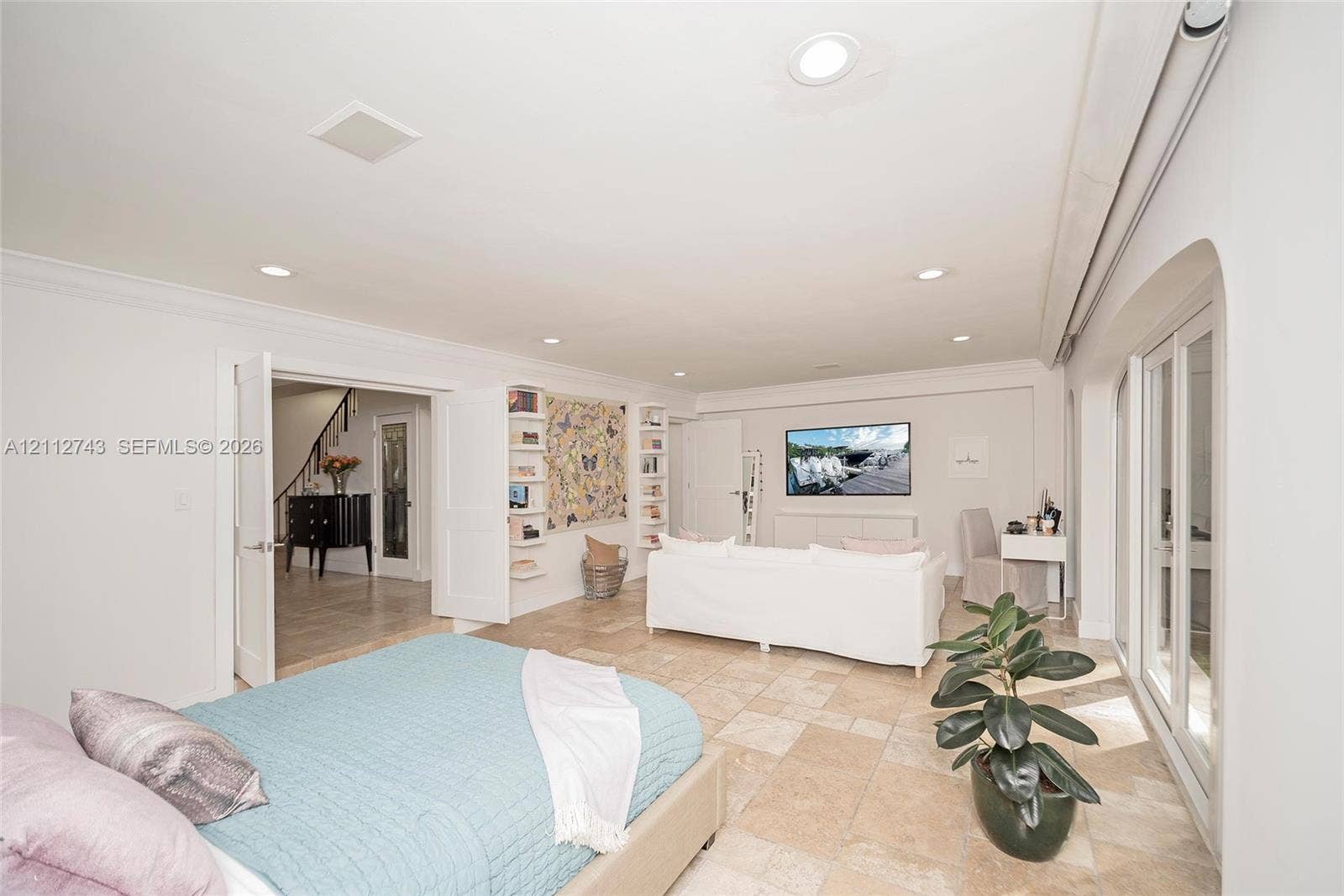 6157 Paradise Point Drive, Palmetto Bay, FL 33157 Neutral-toned stone flooring, recessed lighting, double French doors, and built-in shelving units