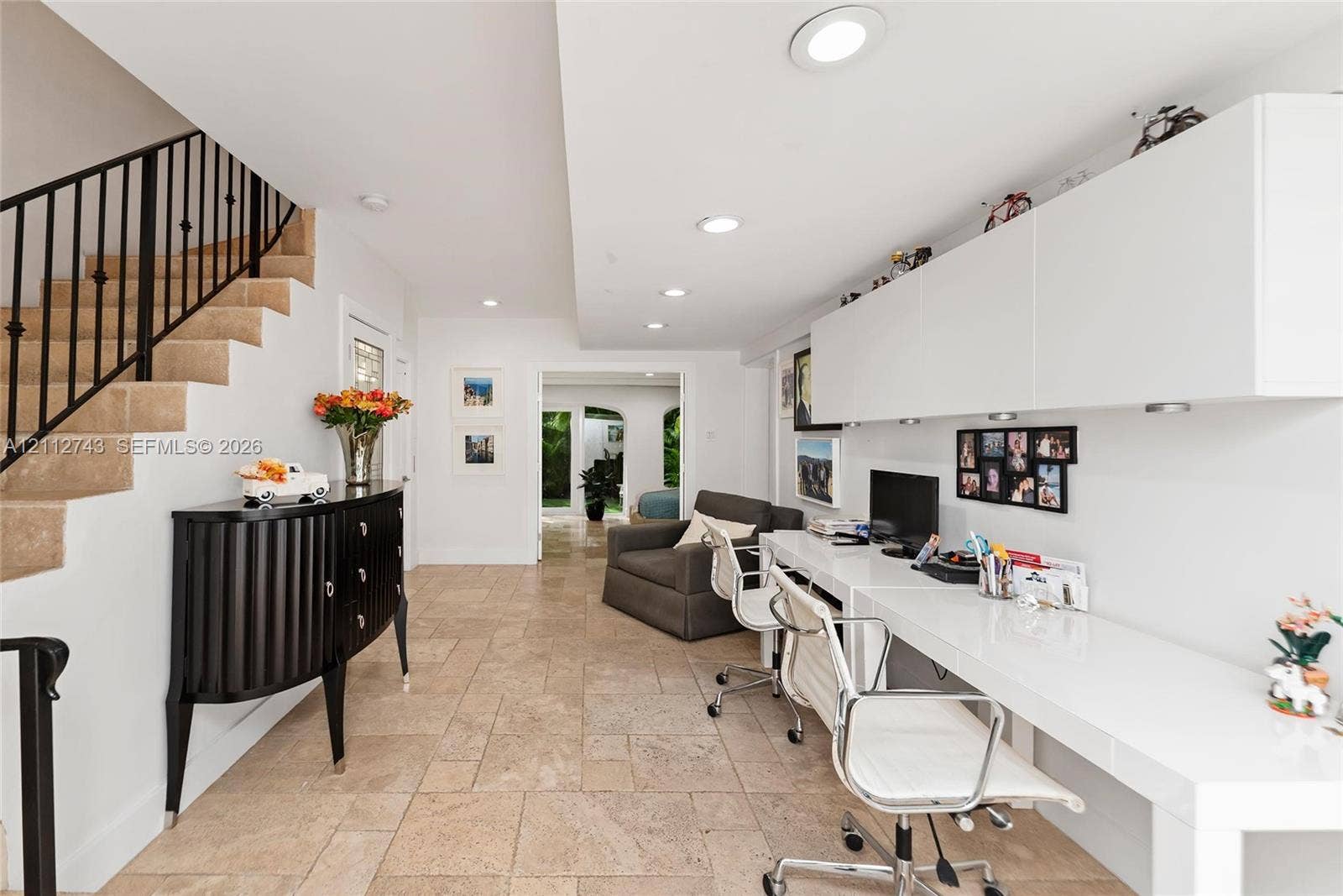 6157 Paradise Point Drive, Palmetto Bay, FL 33157 Stone-tiled flooring, built-in white desk with overhead cabinetry, and staircase featuring a black metal railing