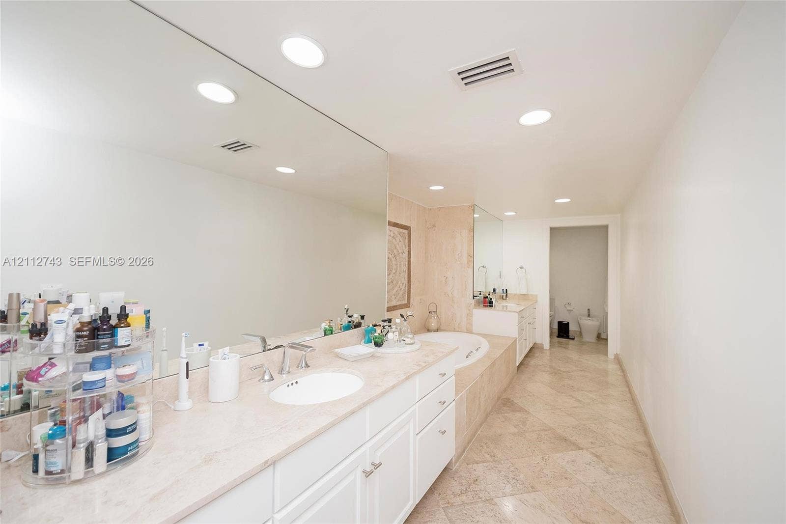 6157 Paradise Point Drive, Palmetto Bay, FL 33157 Dual vanity with stone countertop, large wall-mounted mirror, recessed lighting, and tile flooring
