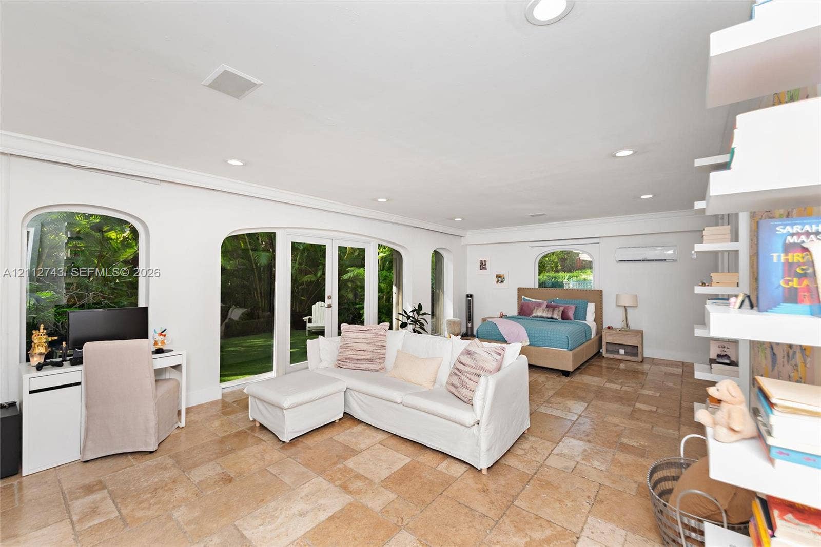 6157 Paradise Point Drive, Palmetto Bay, FL 33157 Spacious interior featuring stone tile flooring, recessed lighting, arched windows, dual-pane glass French doors, and white built-in wall shelving