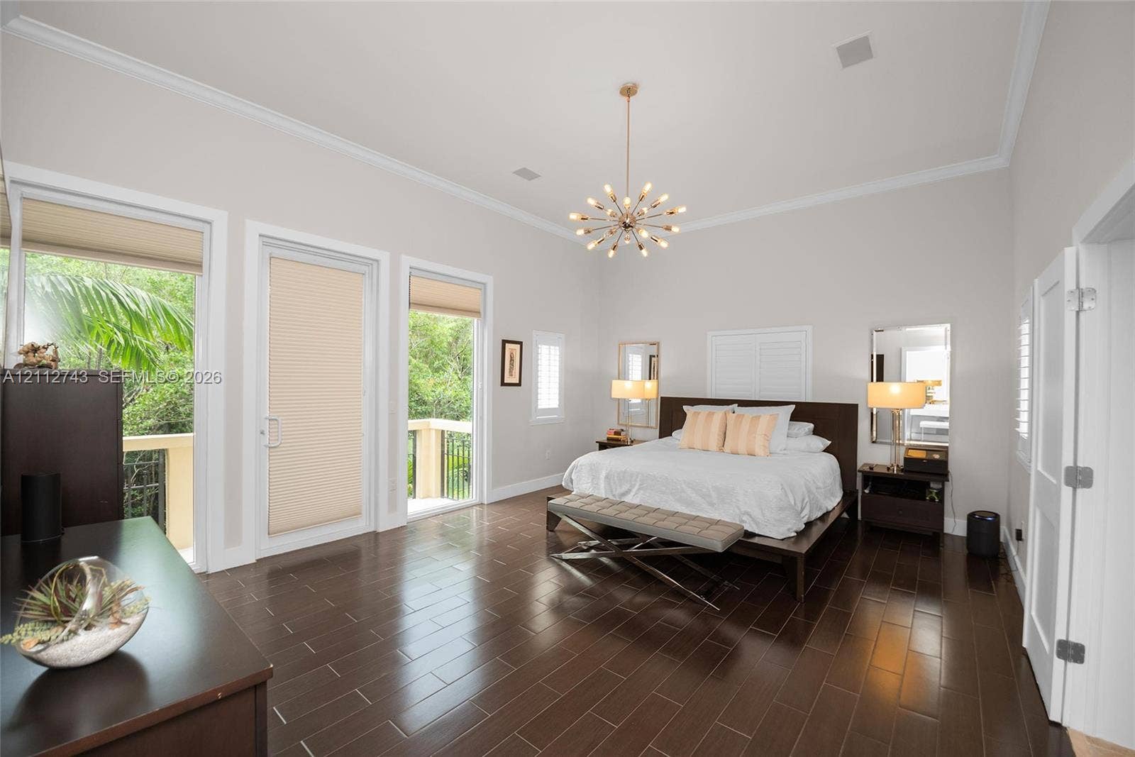 6157 Paradise Point Drive, Palmetto Bay, FL 33157 High ceilings with crown molding, wood-finish flooring, two glass-paneled exterior doors, and a decorative multi-bulb chandelier
