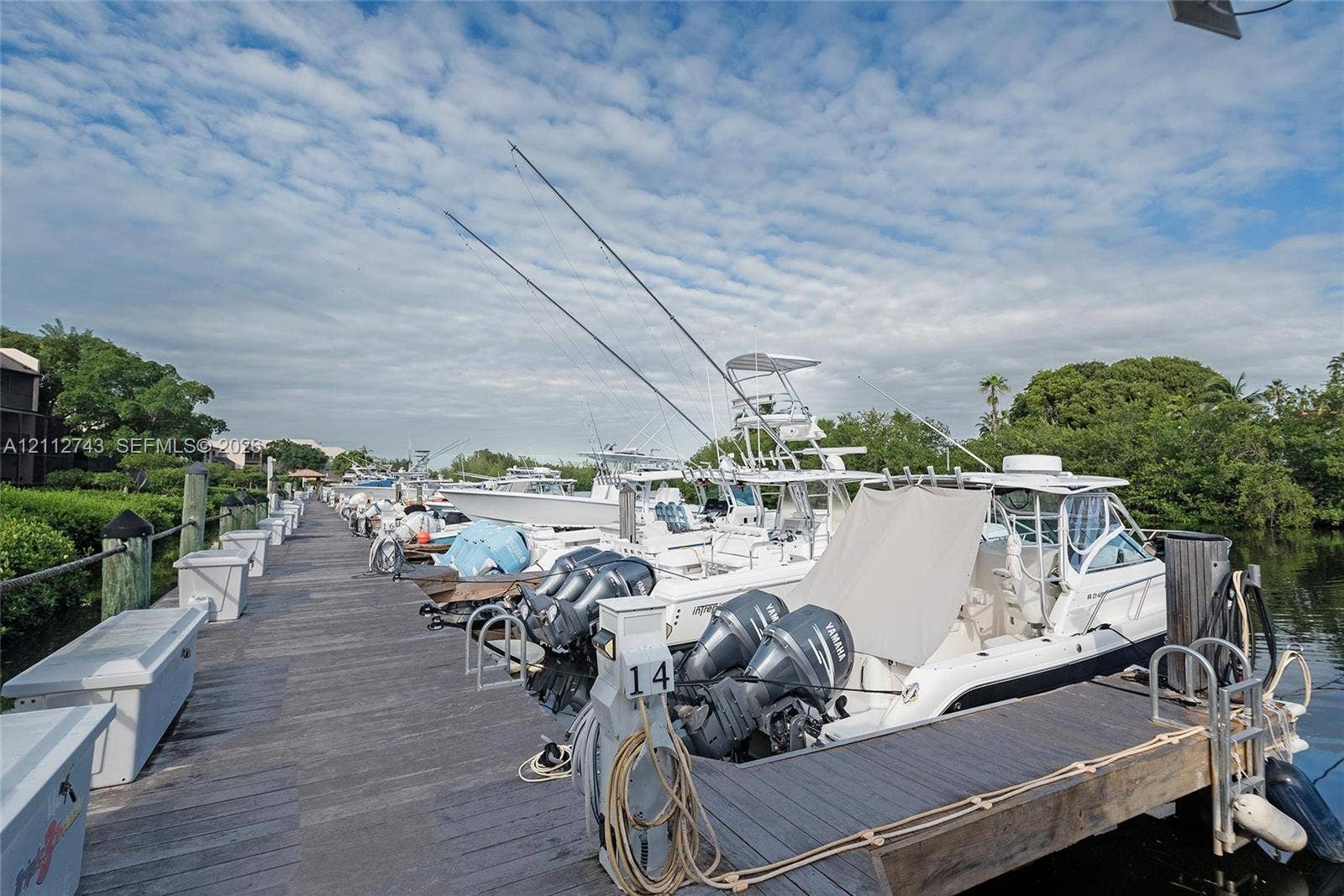 6157 Paradise Point Drive, Palmetto Bay, FL 33157 Deep-water dock featuring wooden planking, integrated electrical pedestals, and sturdy metal piling bollards