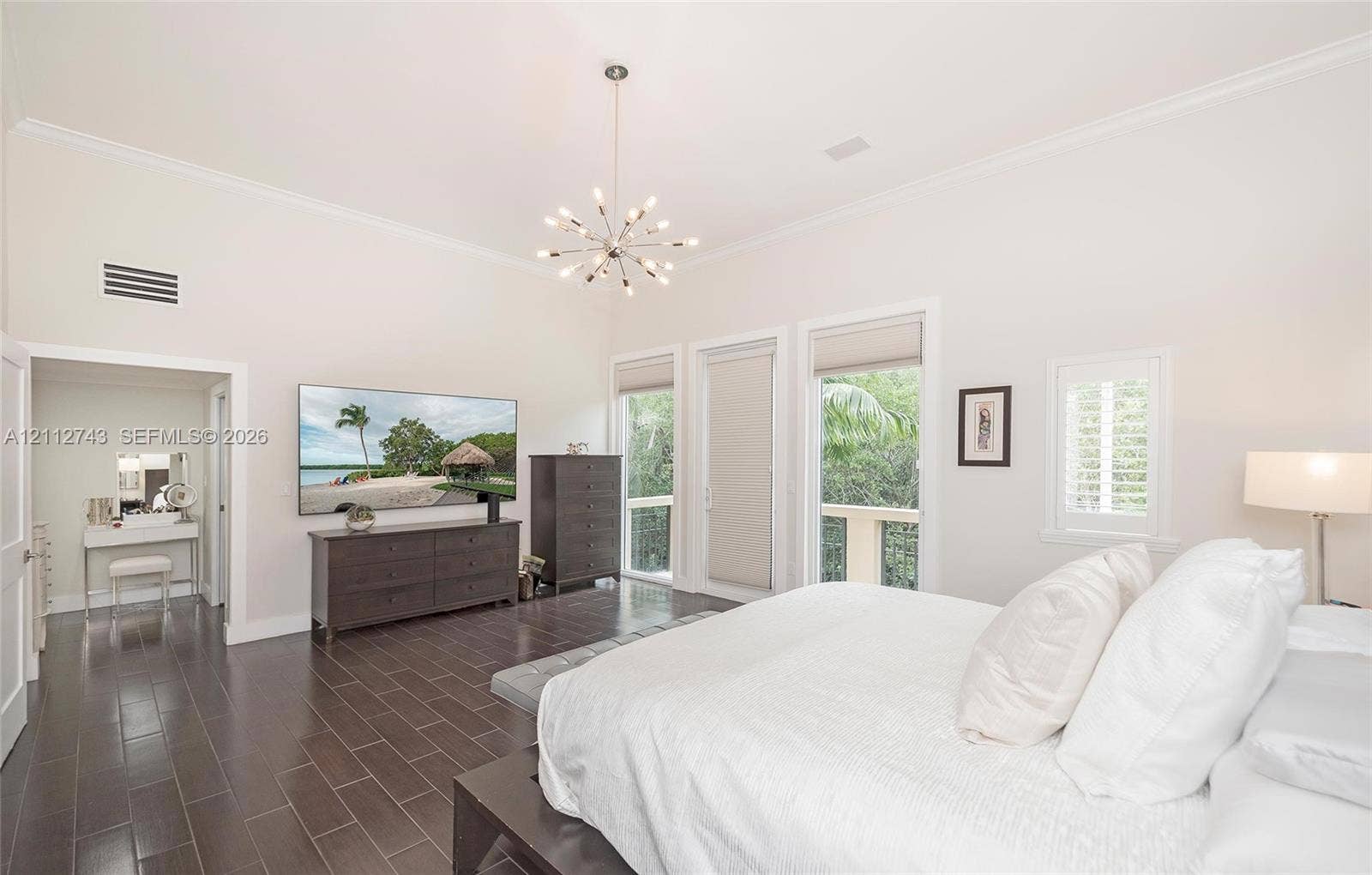 6157 Paradise Point Drive, Palmetto Bay, FL 33157 High ceilings, dark tile flooring, multi-arm sputnik chandelier, and expansive windows with custom roller shades