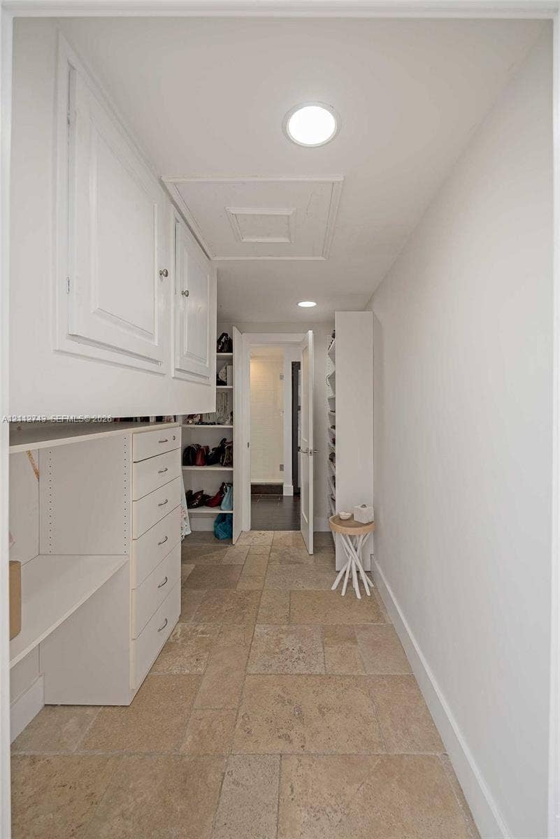 6157 Paradise Point Drive, Palmetto Bay, FL 33157 Storage area featuring stone-finish flooring, custom built-in white cabinetry, integrated drawer banks, and recessed lighting