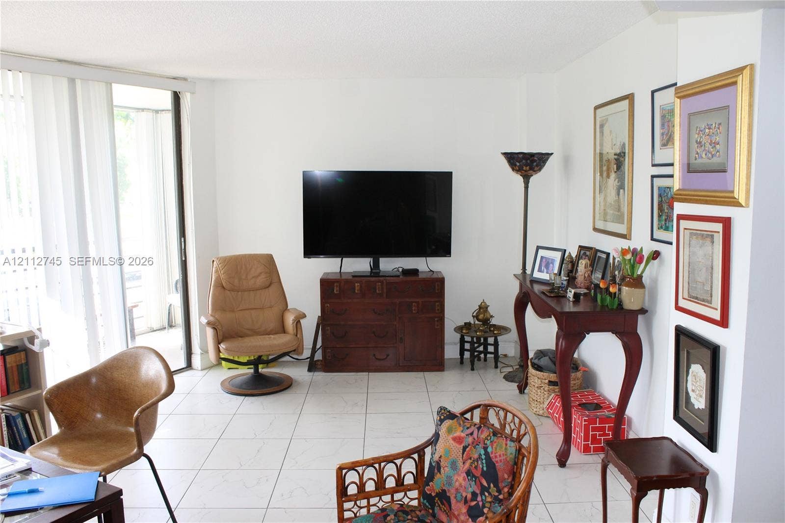 20500 W Country Club Drive, #202, Aventura, FL 33180 Living area featuring large-format tile flooring and sliding glass door access to a private outdoor space