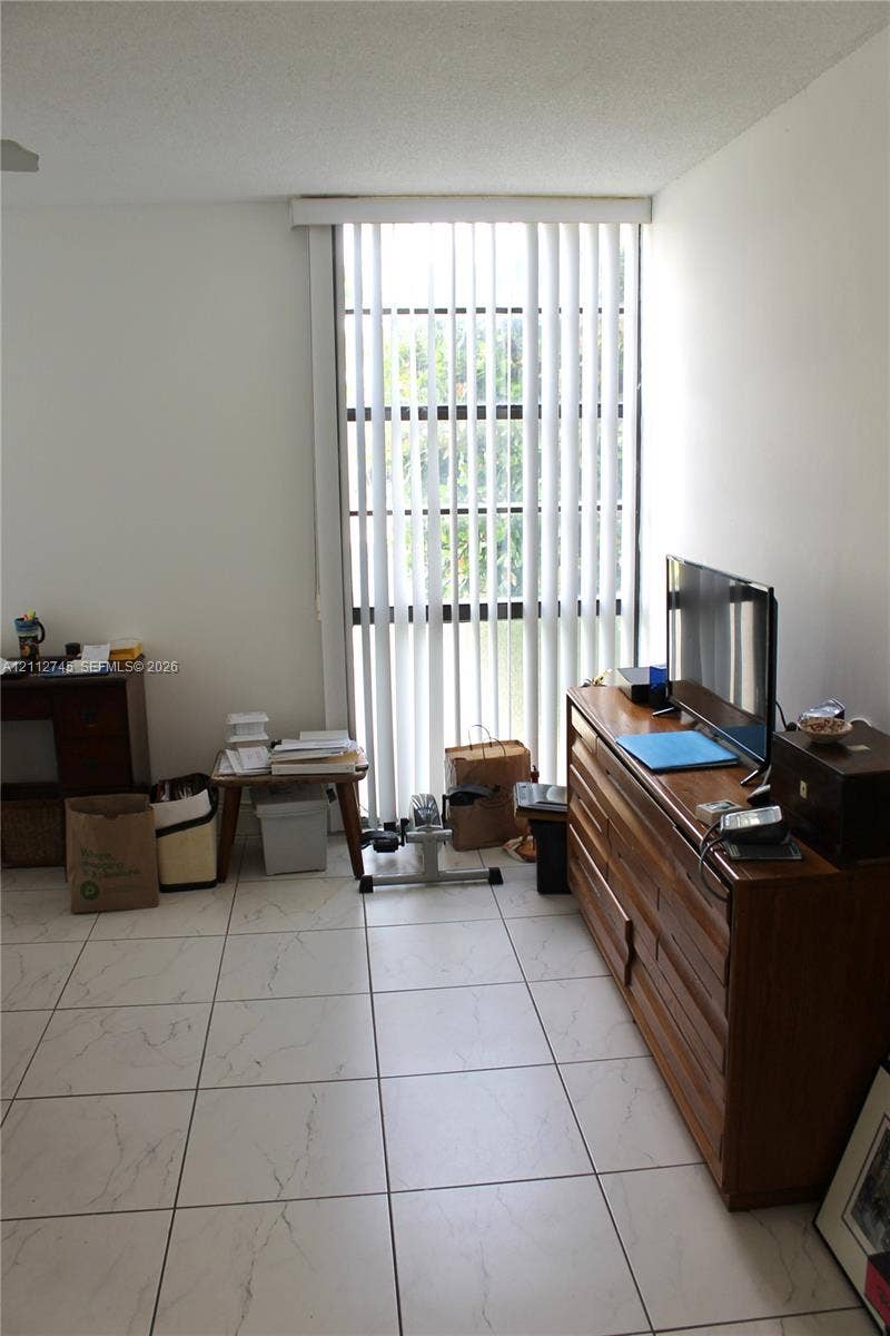 20500 W Country Club Drive, #202, Aventura, FL 33180 Floor-to-ceiling window with vertical blinds and white stone-finish tile flooring