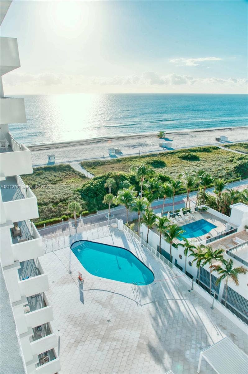 5825 Collins Avenue, #11H, Miami Beach, FL 33140 Outdoor swimming pool surrounded by a paved deck, towering palm trees, and coastal proximity
