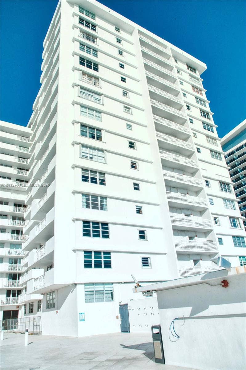 5825 Collins Avenue, #11H, Miami Beach, FL 33140 High-rise residential building featuring a white facade, multi-level private balconies, and grid-patterned windows